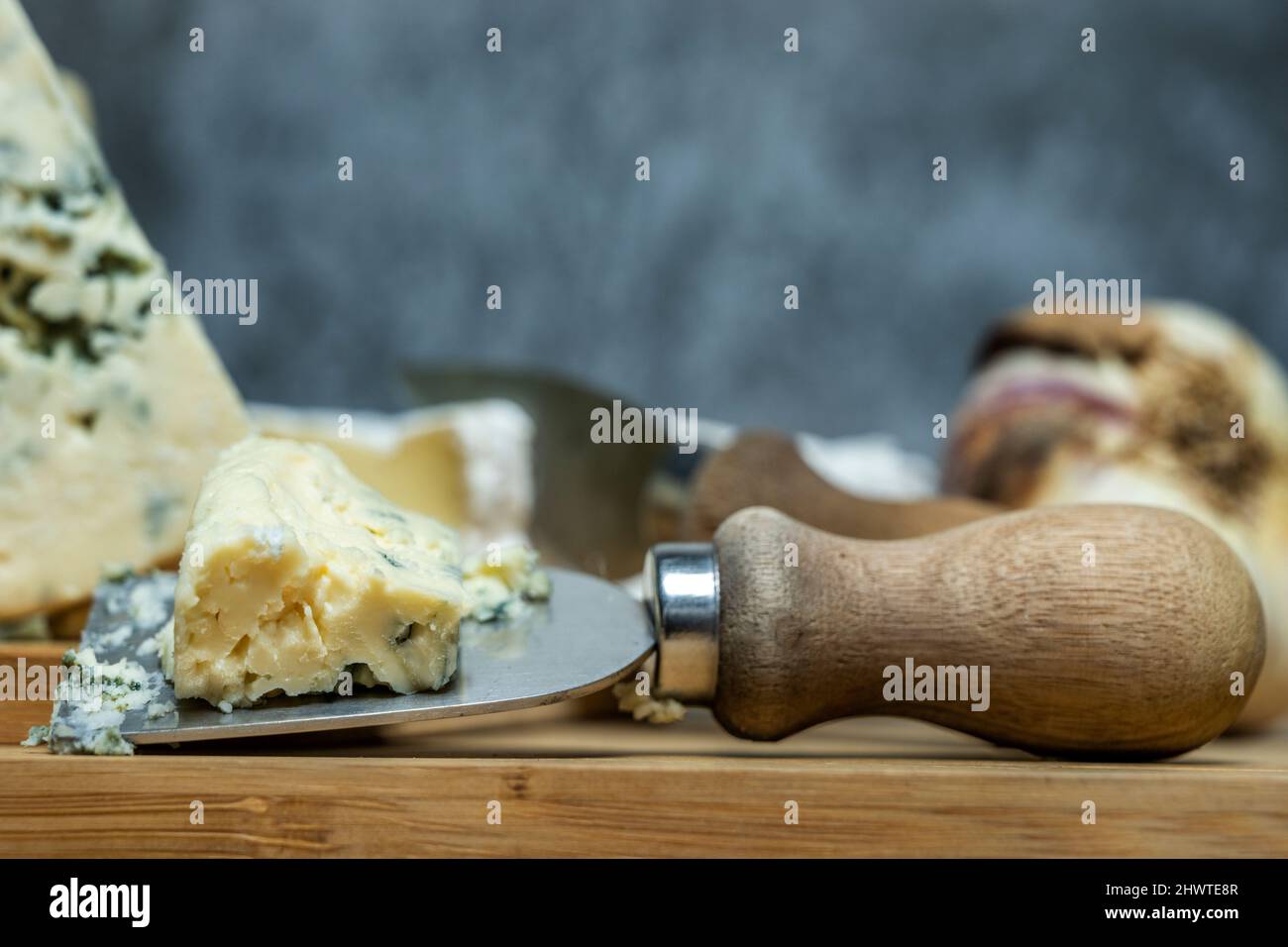 Small cheese knife with a piece of blue cheese ready to sink your teeth into Stock Photo