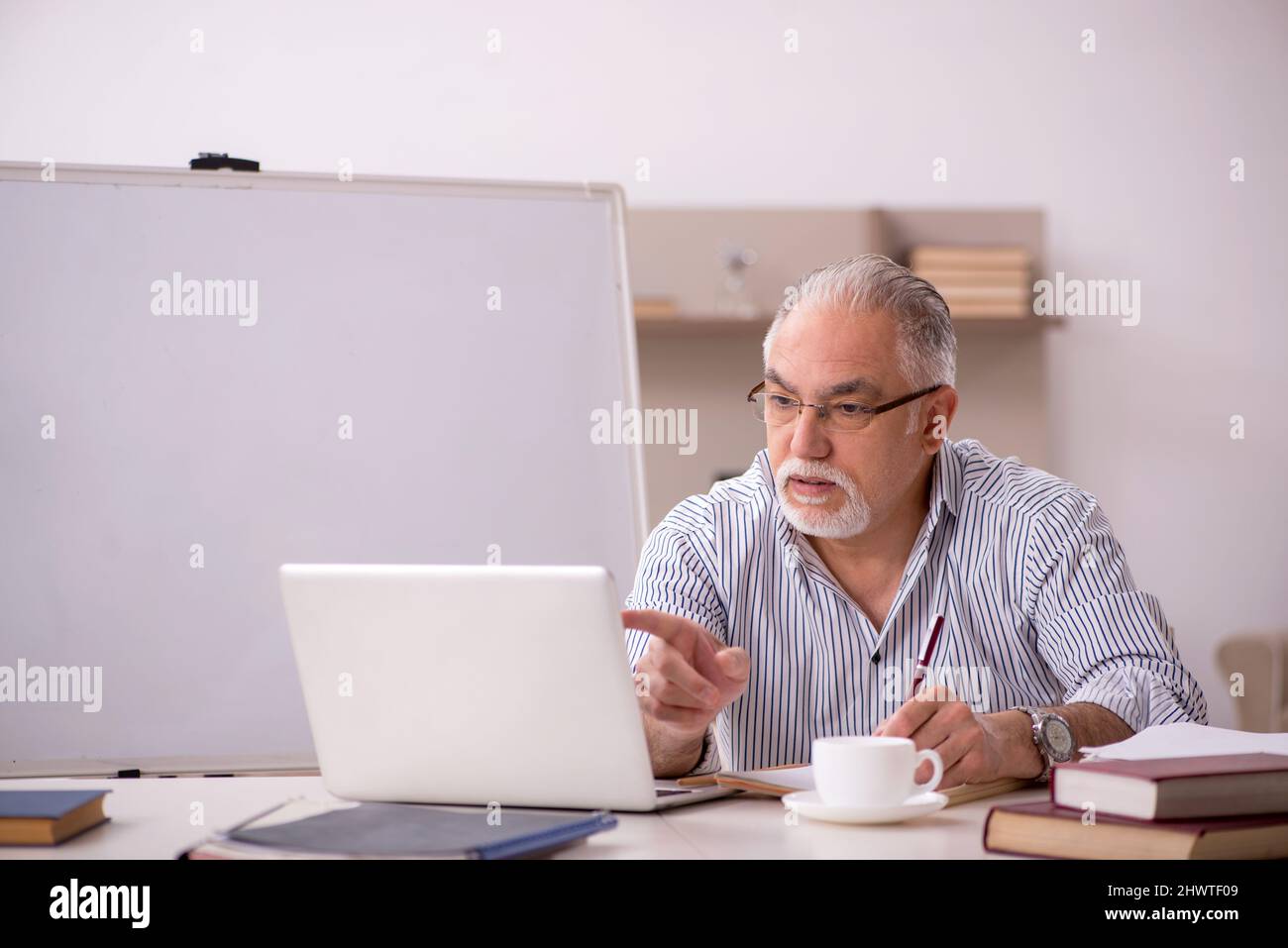 Old businessman employee working from home during pandemic Stock Photo