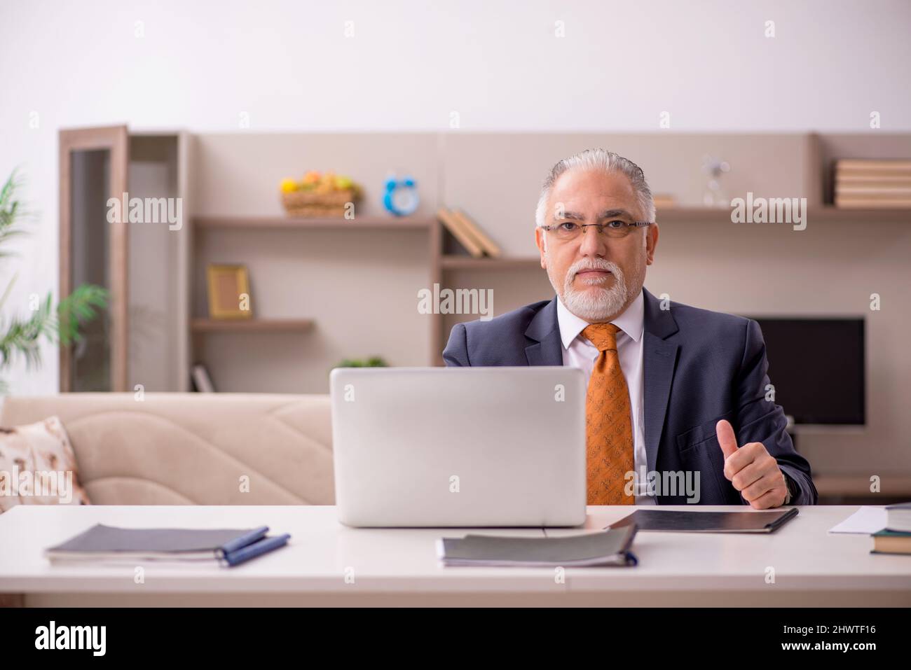 Old businessman employee working from home during pandemic Stock Photo