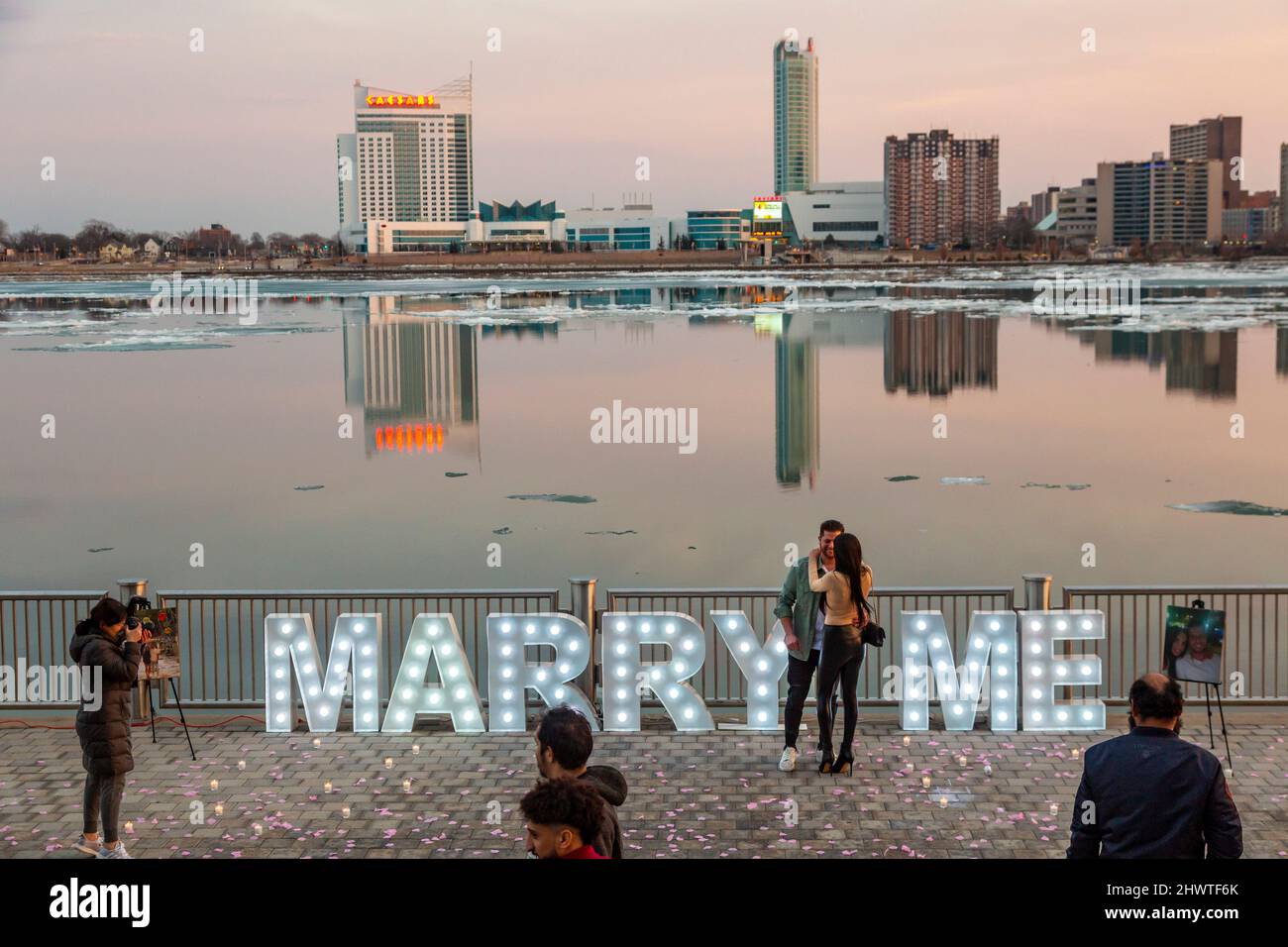 Detroit, Michigan - A happy couple celebrates along the Detroit Riverwalk after the man's public marriage proposal was accepted. Stock Photo