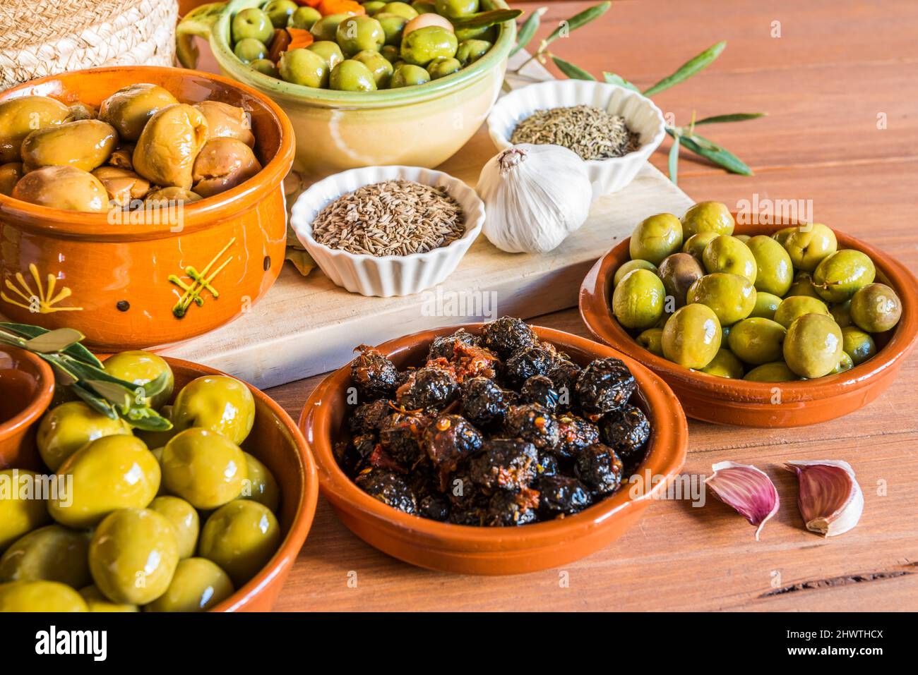 Still life with different varieties of olives, presented in bowls, dressed with different traditional dressings. Traditional homemade dressings, typic Stock Photo