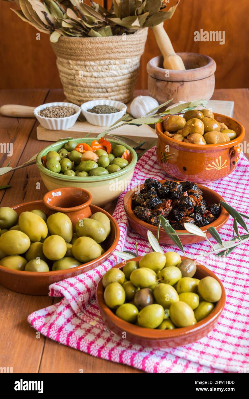 Still life with different varieties of olives, presented in bowls, dressed with different traditional dressings. Traditional homemade dressings, typic Stock Photo