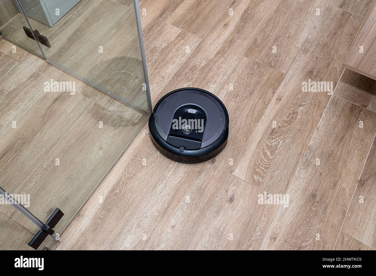 A modern robotic vacuum cleaner cleans the ceramic tiles in the