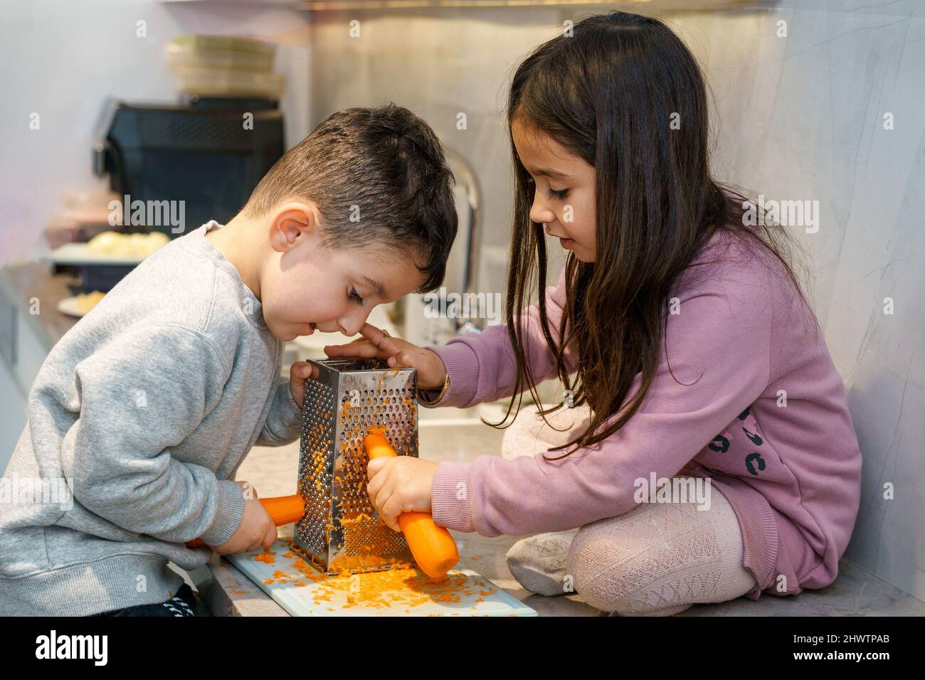 chef shredding carrots with grater in kitchen Stock Photo - Alamy