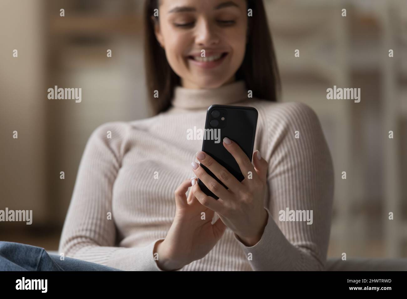 Happy young woman use smartphone, closeup focus on device Stock Photo