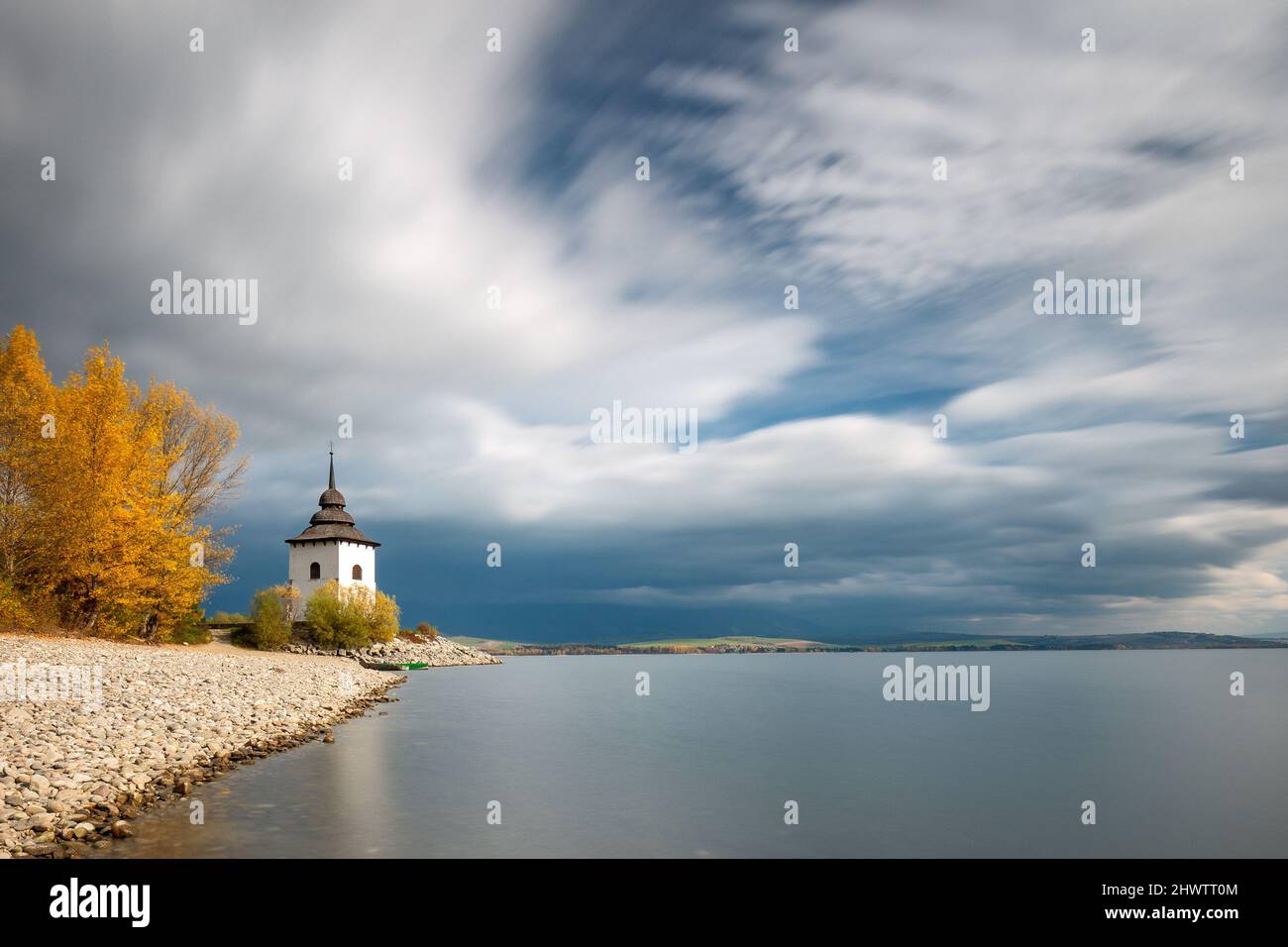 Church Tower of Virgin Mary at the shore of The Liptovska Mara dam in the morning light at autumn, the area of Liptov in Slovakia, Europe. Long time e Stock Photo