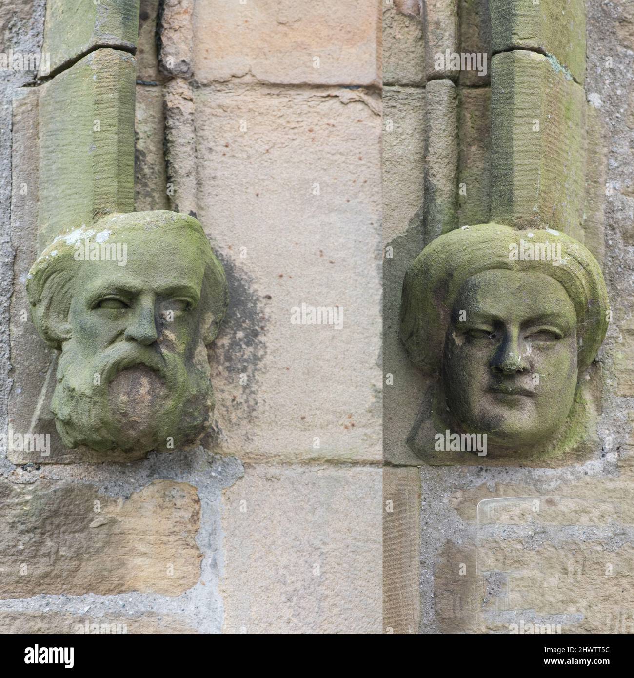 Sculpted stone heads (both male & female) are either side of  the main entrance doors to Long Preston Village hall (the former Mechanics Institute). Stock Photo