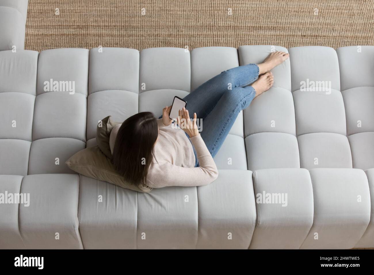 Overhead view woman relax on sofa use smartphone Stock Photo Alamy