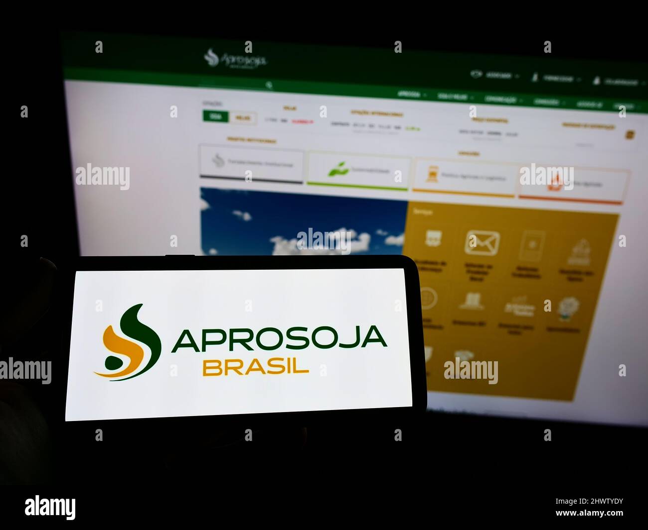 Person holding smartphone with logo of Brazilian agriculture company
