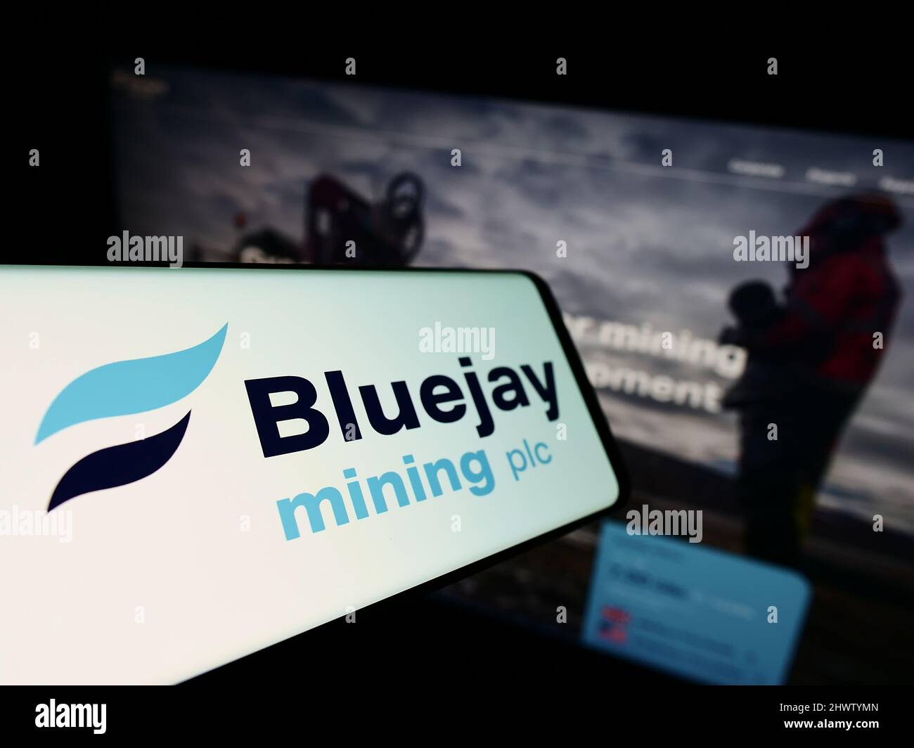 Smartphone with logo of British company Bluejay Mining plc on screen in front of business website. Focus on center-left of phone display. Stock Photo