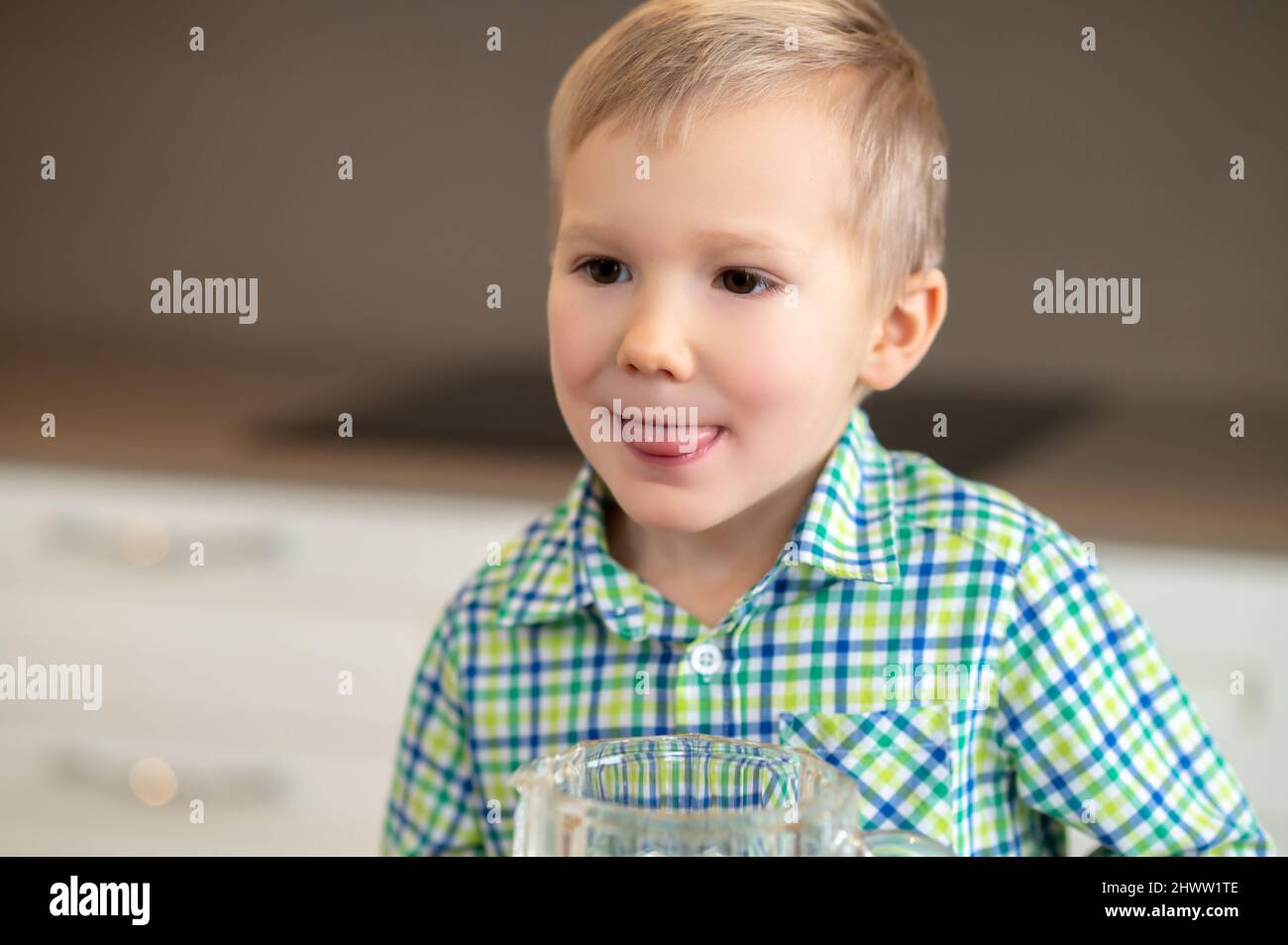 Kid with his tongue stuck out staring into the distance Stock Photo