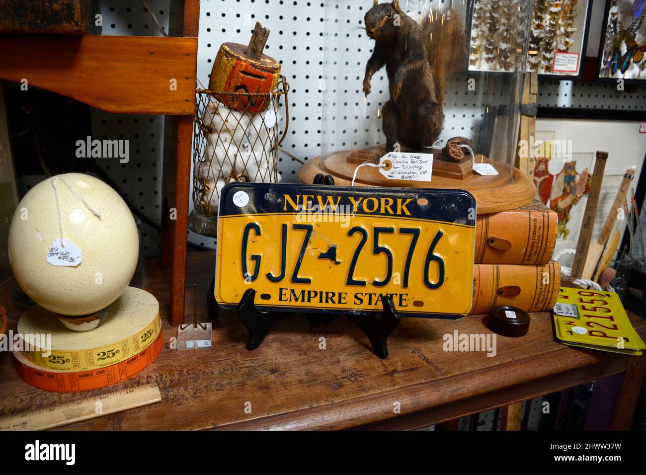 An expired New York state automobile license plate for sale in an antique shop. Stock Photo
