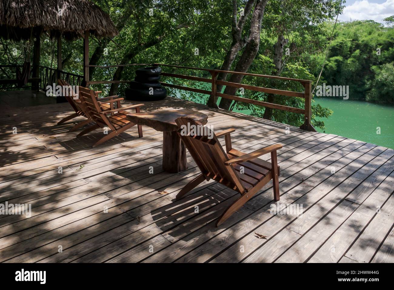 River side jetty with wooden chairs for swimming surrounded by lush tropical jungle at Mopan river, Bullet Tree Falls, Belize Stock Photo