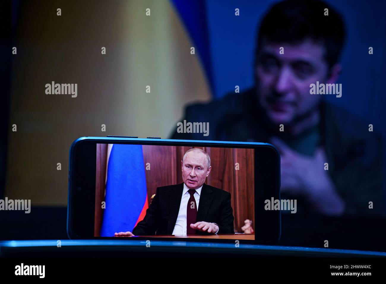 Vladimir Putin speech on TV. Volodymyr Zelensky the president of Ukraine in the background . Volodymyr Zelenskyy speech to people on TV Stock Photo