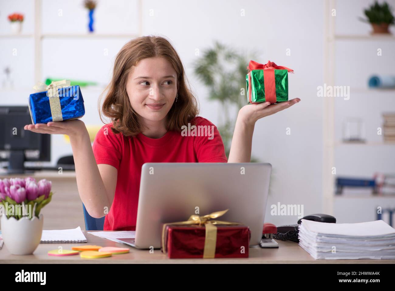 Young female designer celebrating Christmas at workplace Stock Photo