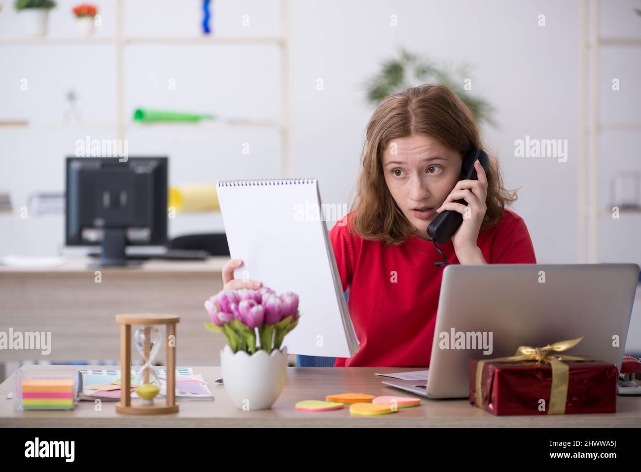 Young female designer celebrating Christmas at workplace Stock Photo