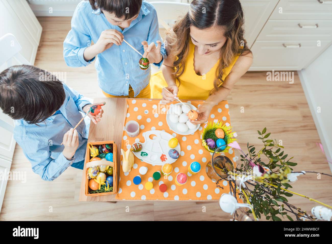 Top-down view of family coloring Easter eggs Stock Photo