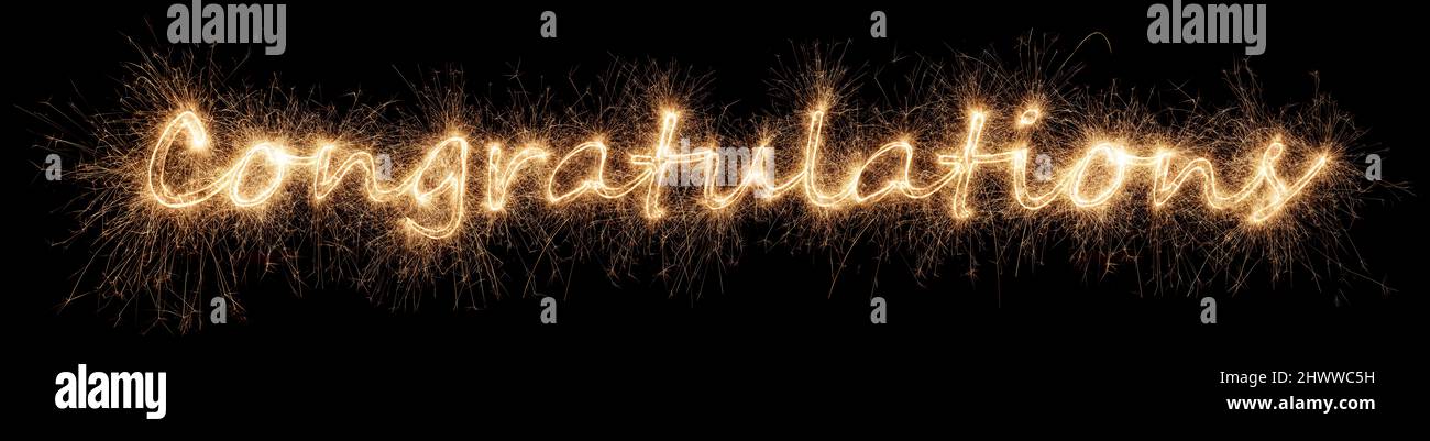 golden bright Congratulations sparkler letter lettering  isolated on dark black background. anniversary, wedding and happy birthday celebration party Stock Photo