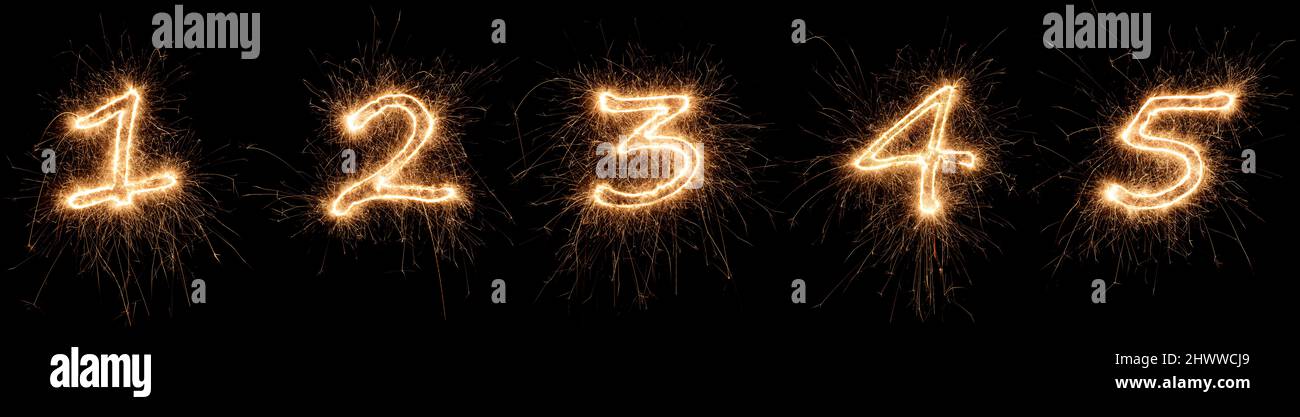 golden bright sparkler number digits font set collection part 1 to 5 isolated on dark black background. silvester new year birthday and celebration de Stock Photo