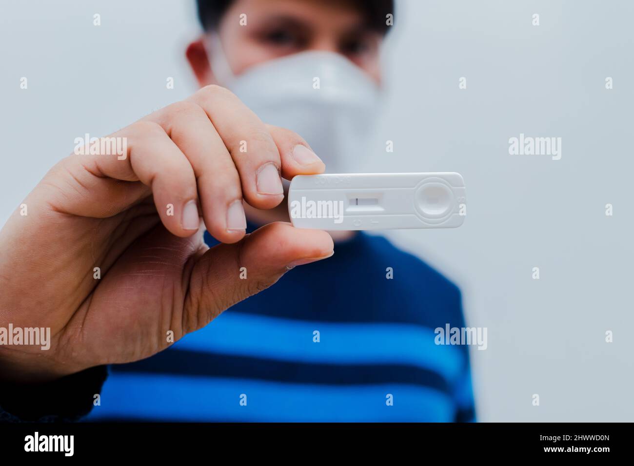 man holding Rapid Antigen Test kit with Positive result during swab