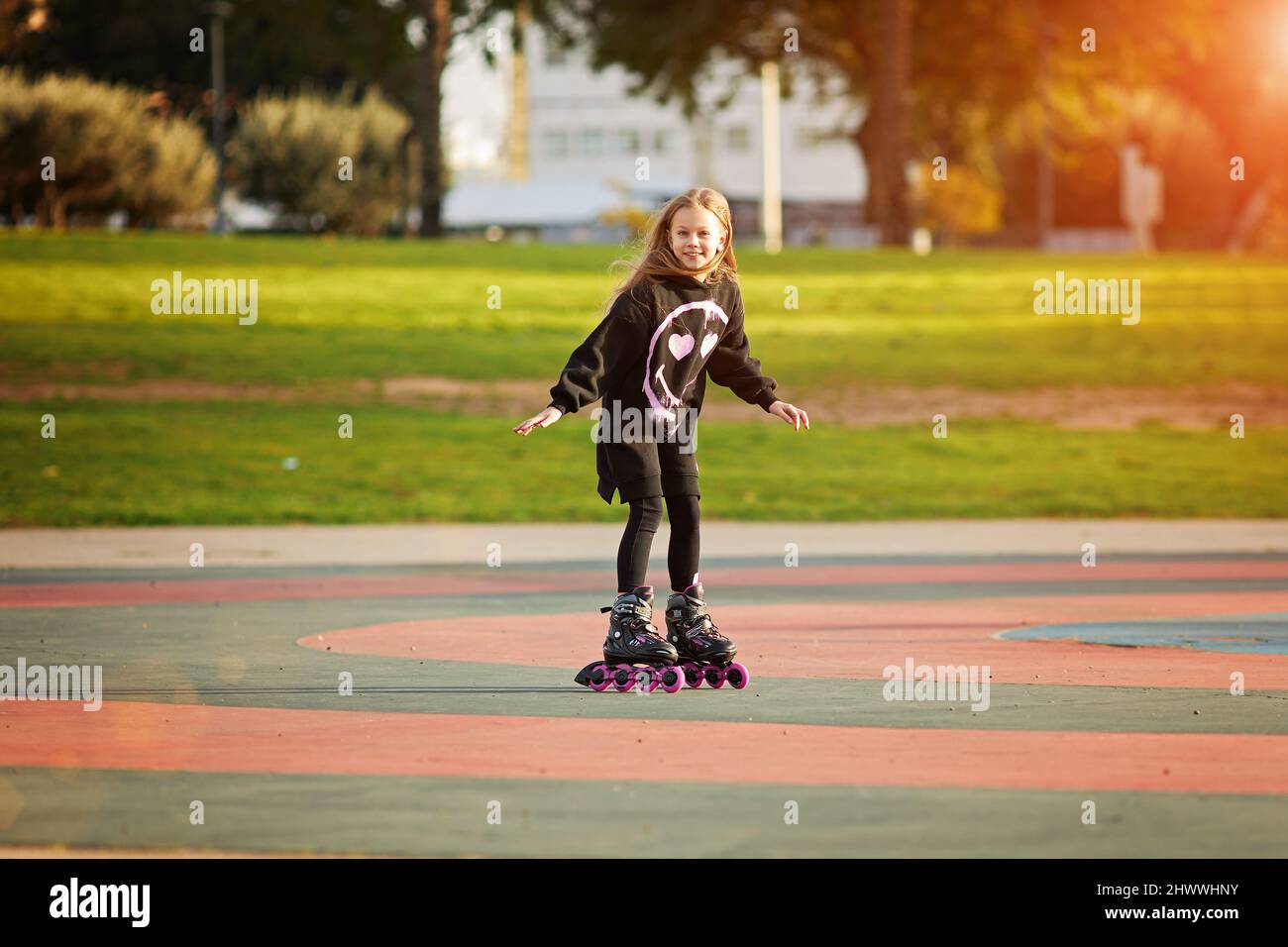 portrait of young child or teen girl roller skating outdoors, fitness, well being, active healthy lifestyle Stock Photo