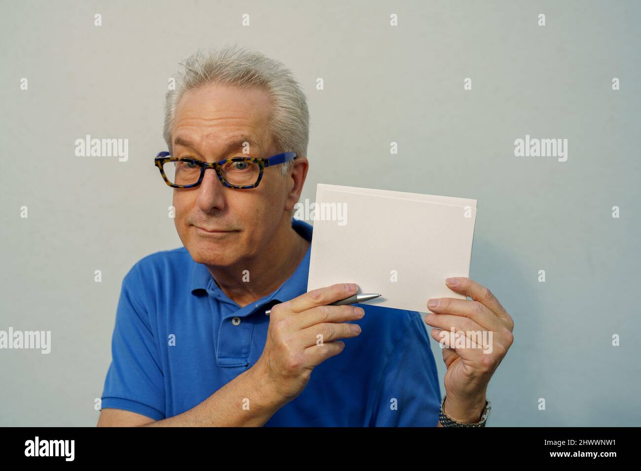 Old man holding a blank postcard Stock Photo