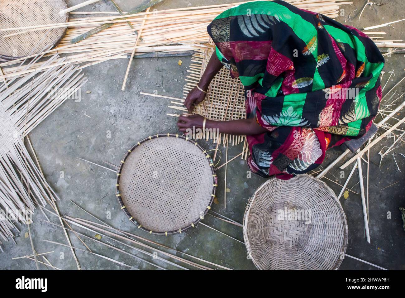 A woman entrepreneur is showing her basket made with Bamboo in the Netrkona district of Bangladesh. It is also helping other women to earn money. Stock Photo