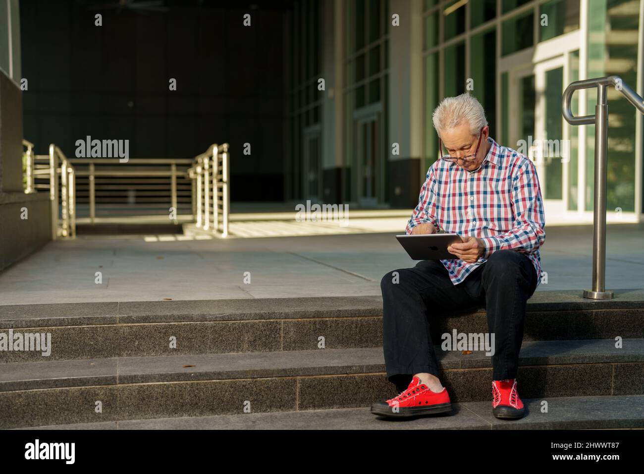 Cool senior businessman working on a tablet Stock Photo