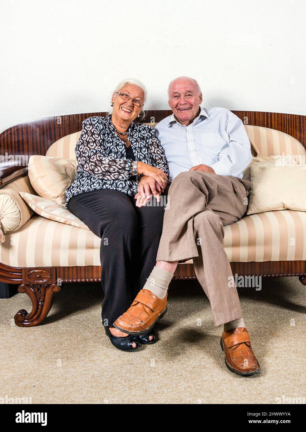 caucasian senior  couple in love sitting on a sofa Stock Photo