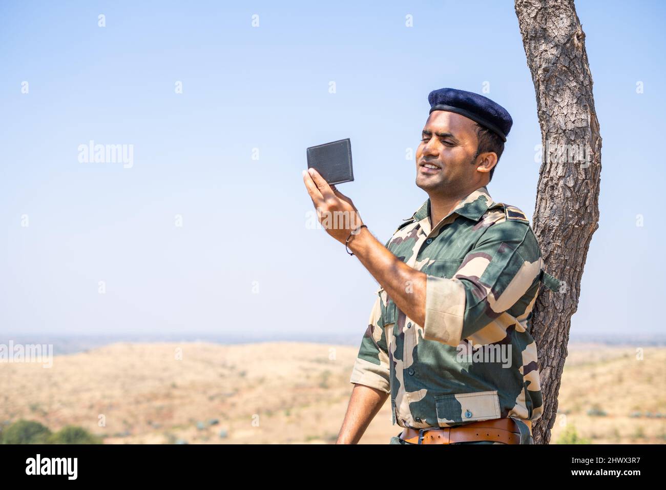 Soldier remebers his family by seeing photo from wallet during service - concept of family affection, bonding and happiness. Stock Photo