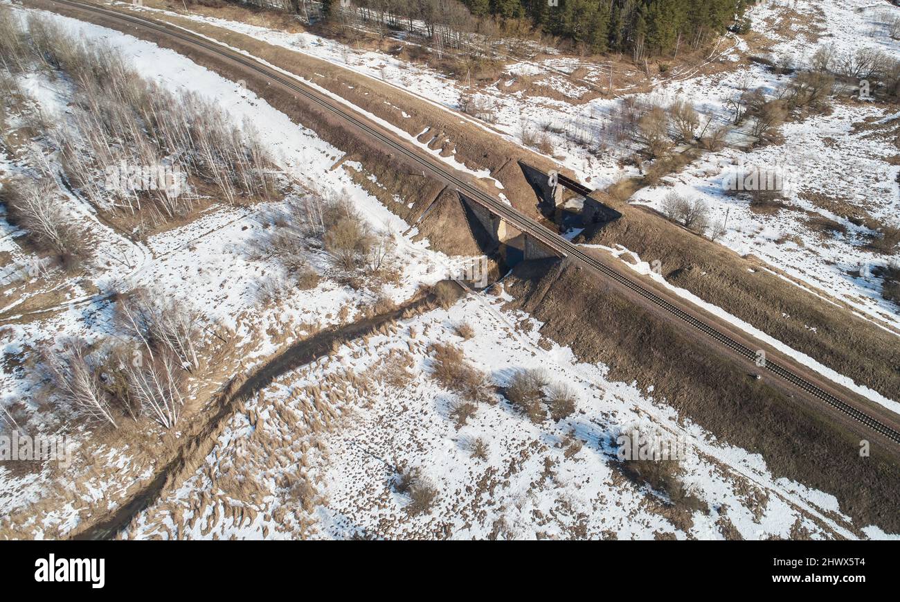 Empty railroad bridge over small river in winter time Stock Photo