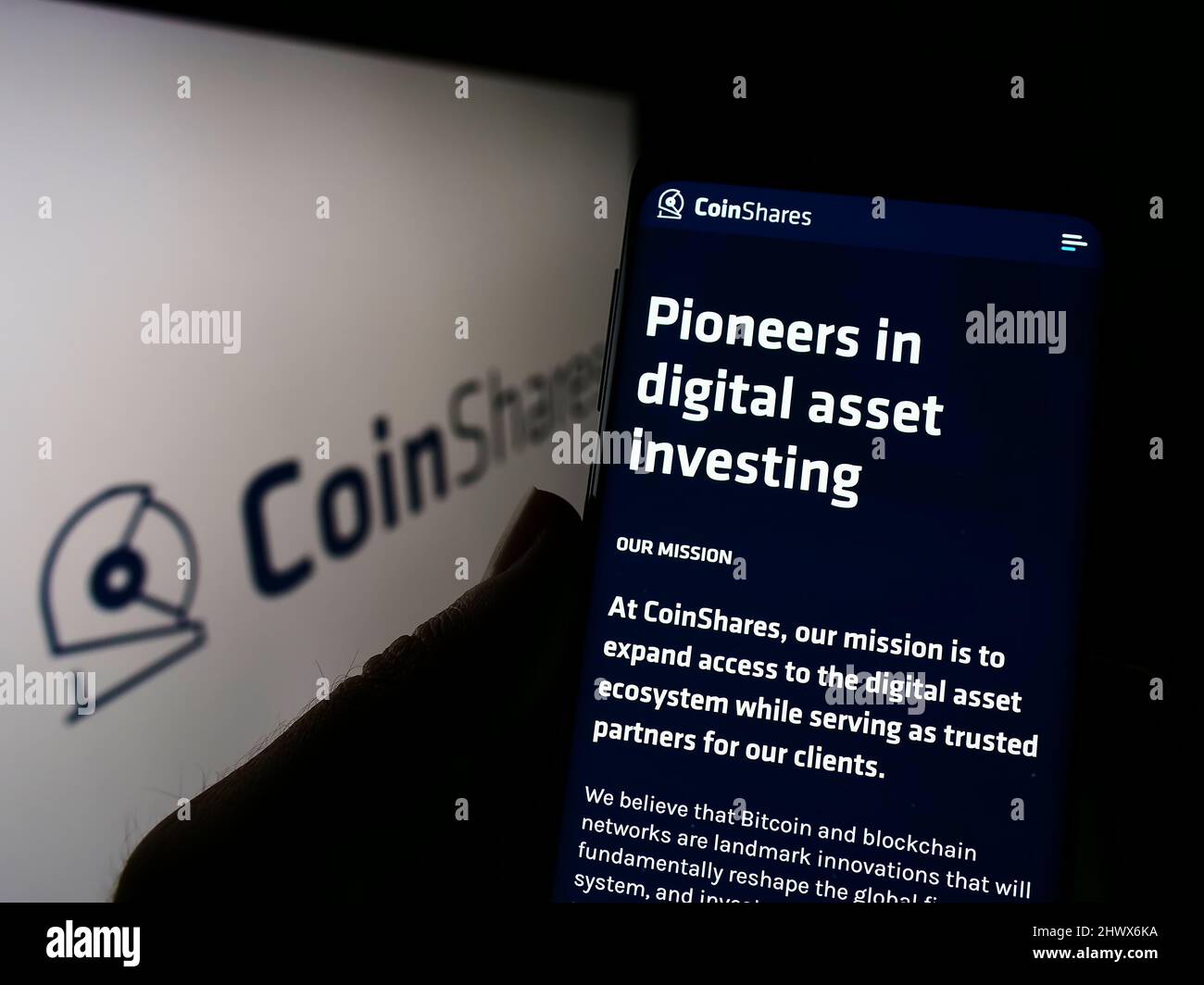 Person holding cellphone with webpage of British investment company