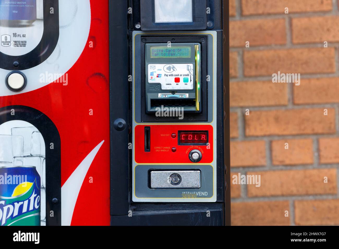 Traditional cash, and cashless, contactless, credit card payment options on a soda vending machine. Stock Photo