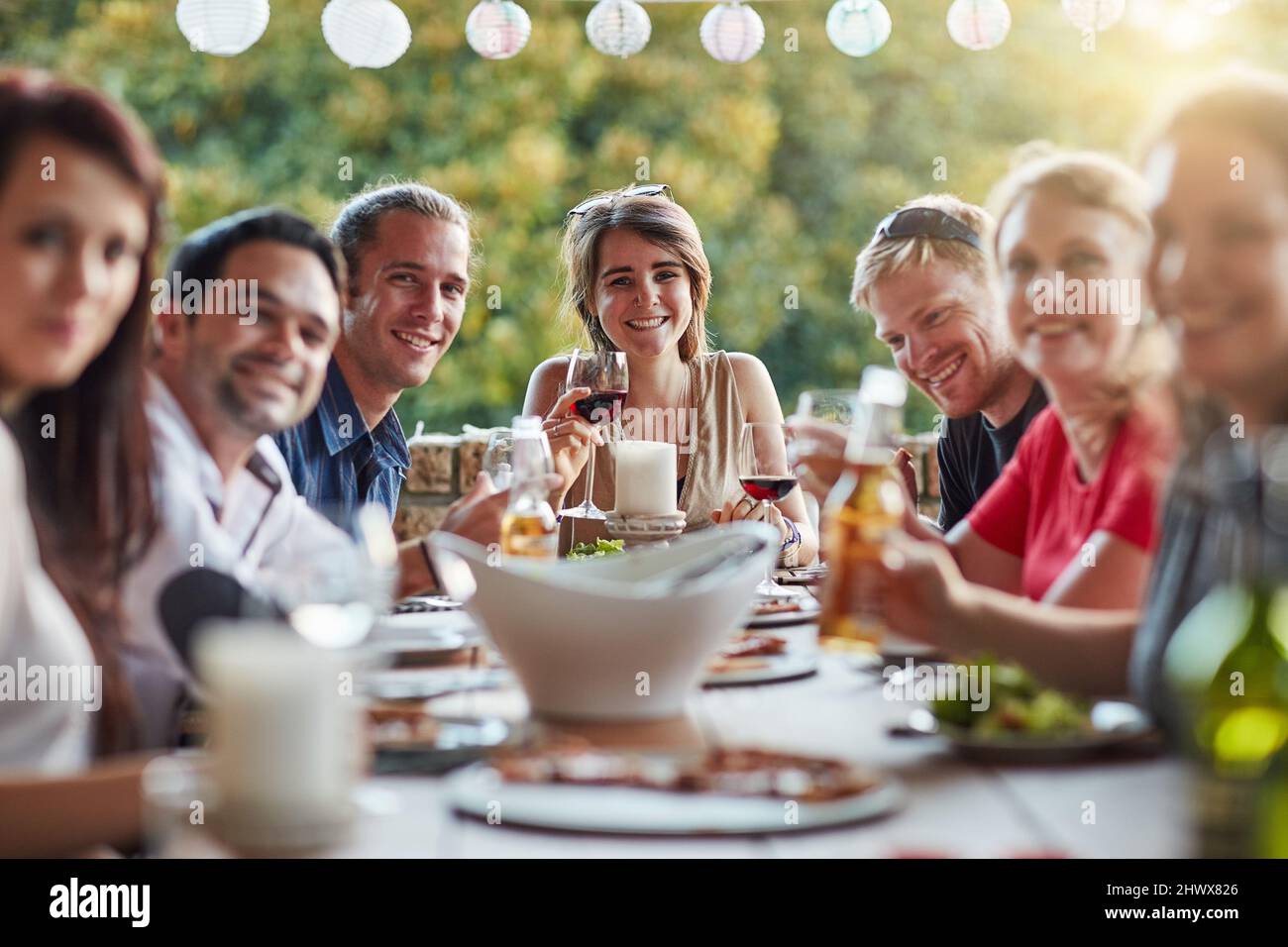 Nothing by good vibes at our table. Portrait of a group of happy young friends sharing a meal at a backyard dinner party. Stock Photo