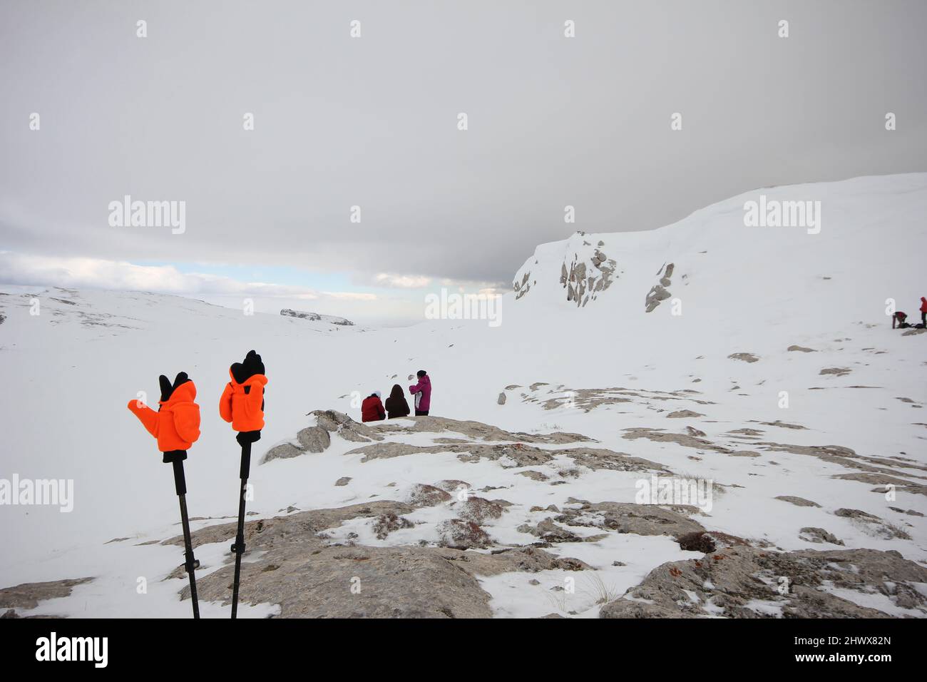 People resting after climbing. Gloves and walking poles. Stock Photo