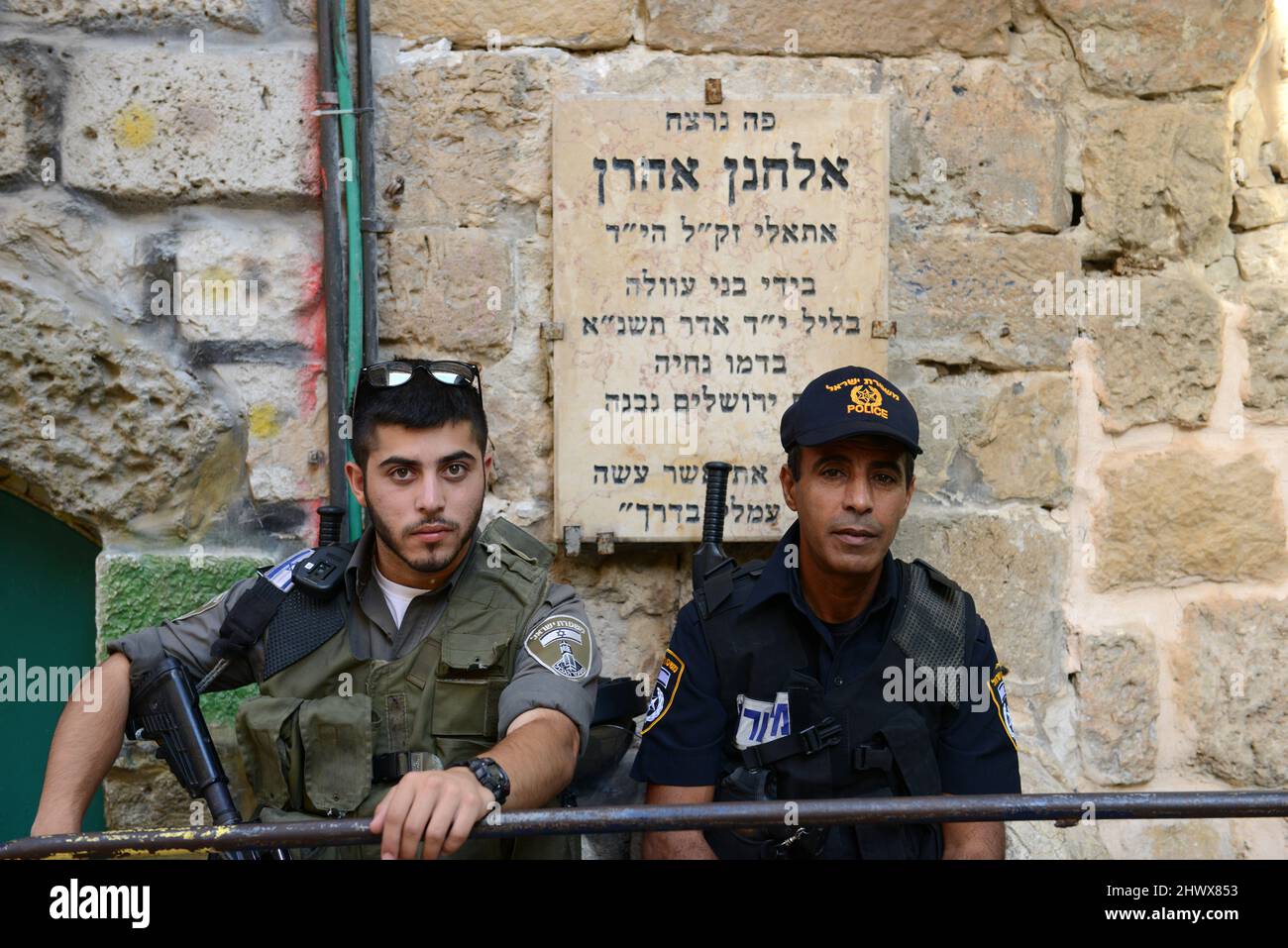 Israeli border policeman and a policeman standing in front of a memorial stone for a Jewish terror victim  on  Hagai Street in Jerusalem's Old city. Stock Photo