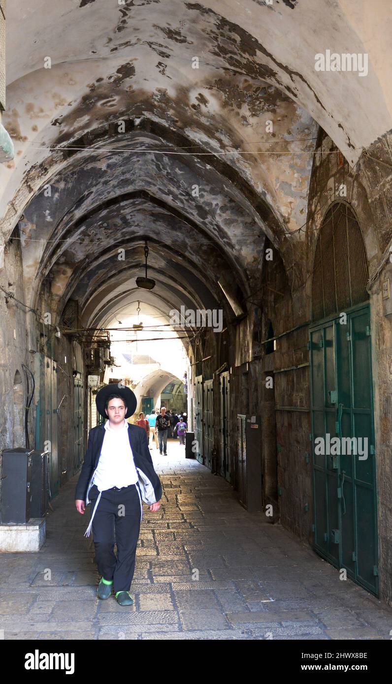A Jewish Yeshiva boy walking on Al-Wad street in the Muslim quarter in the old city of Jerusalem. Stock Photo