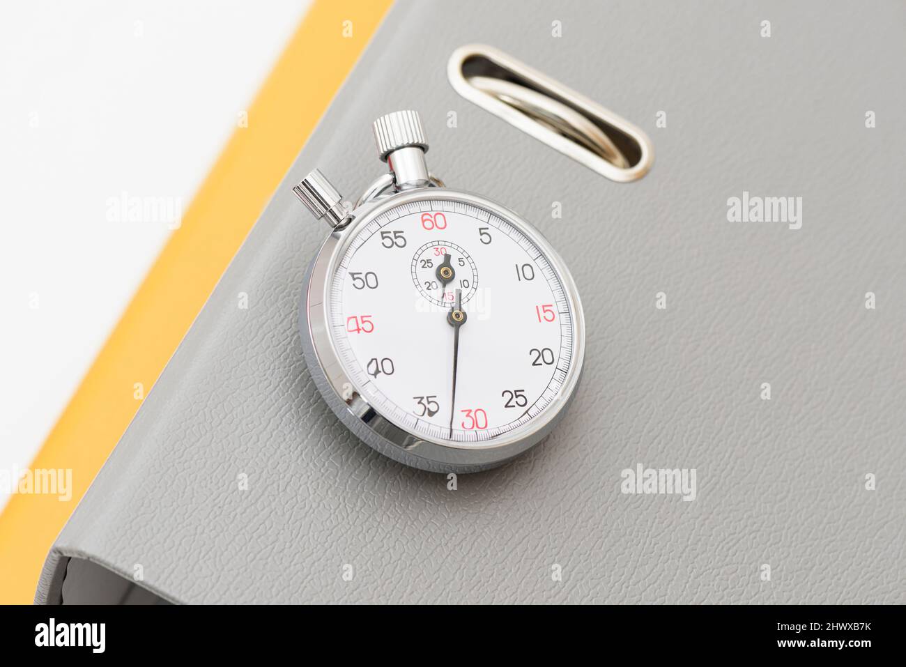 Grey and yellow office folder on the chronometer. Stock Photo