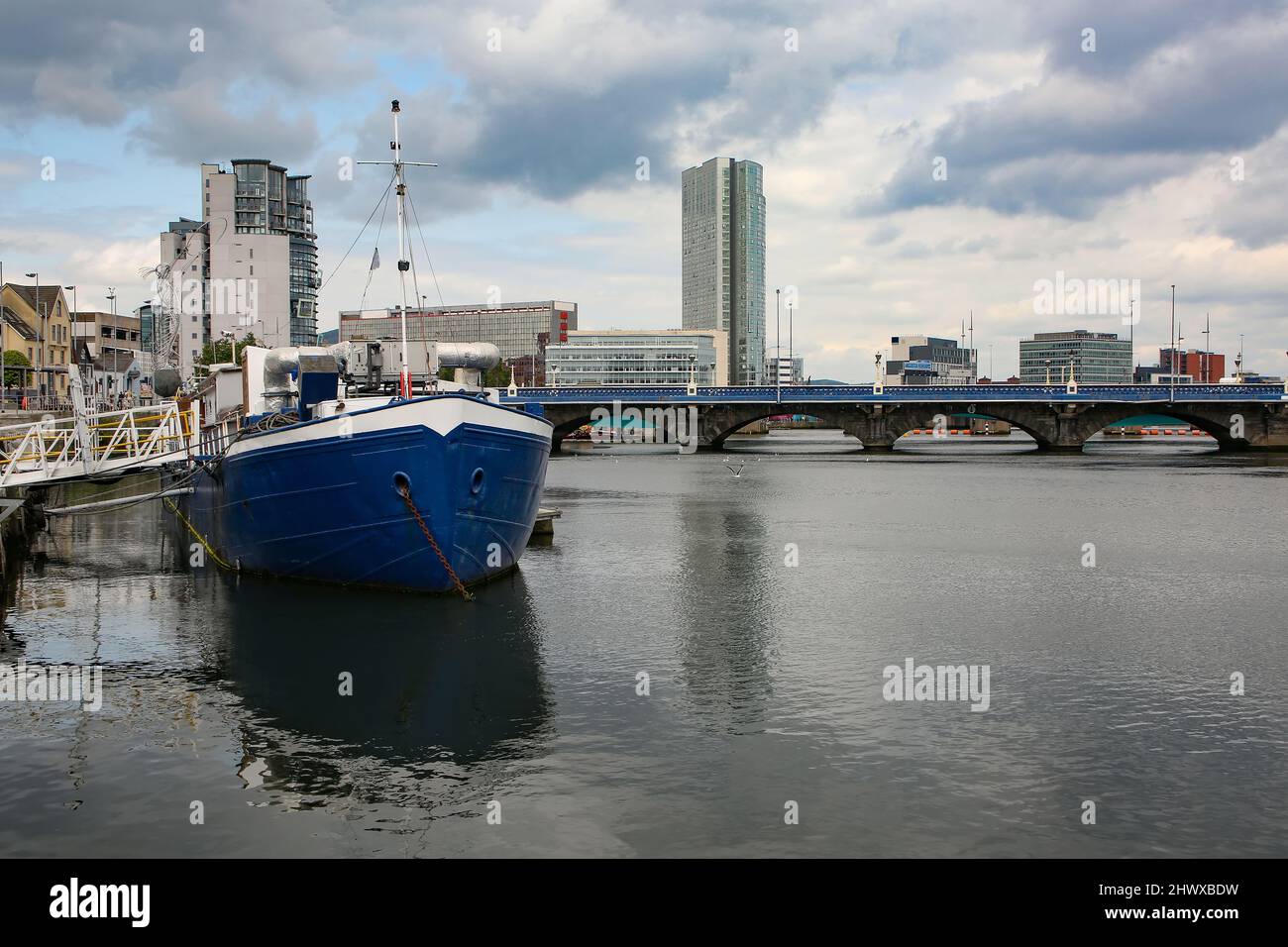 View down the River Lagan, from the Donegall Quay with many bridges over the water and fishing boats in the city center. Belfast, Northern Ireland. Stock Photo