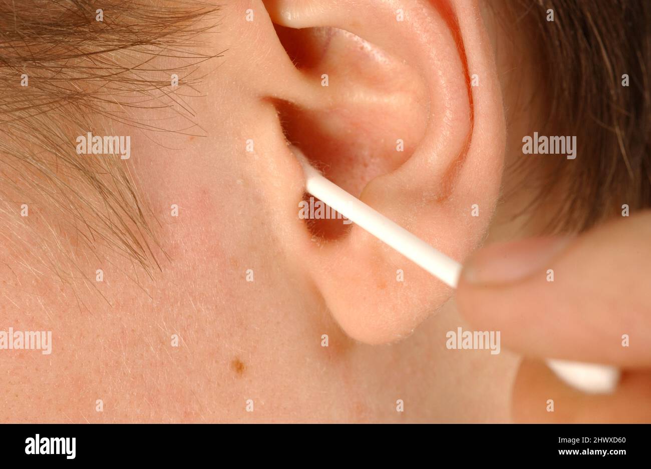 A man cleans his ear canal with a cotton bud. Model Released Stock Photo Alamy