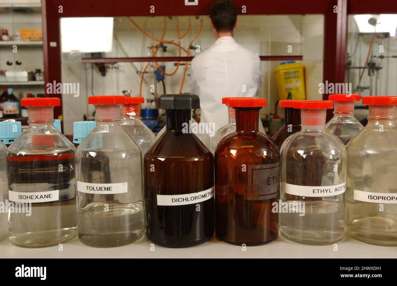 Glass bottles containing the chemicals isohexane, toluene, dichloromethane, ethyl acetate and isopropanol. Stock Photo