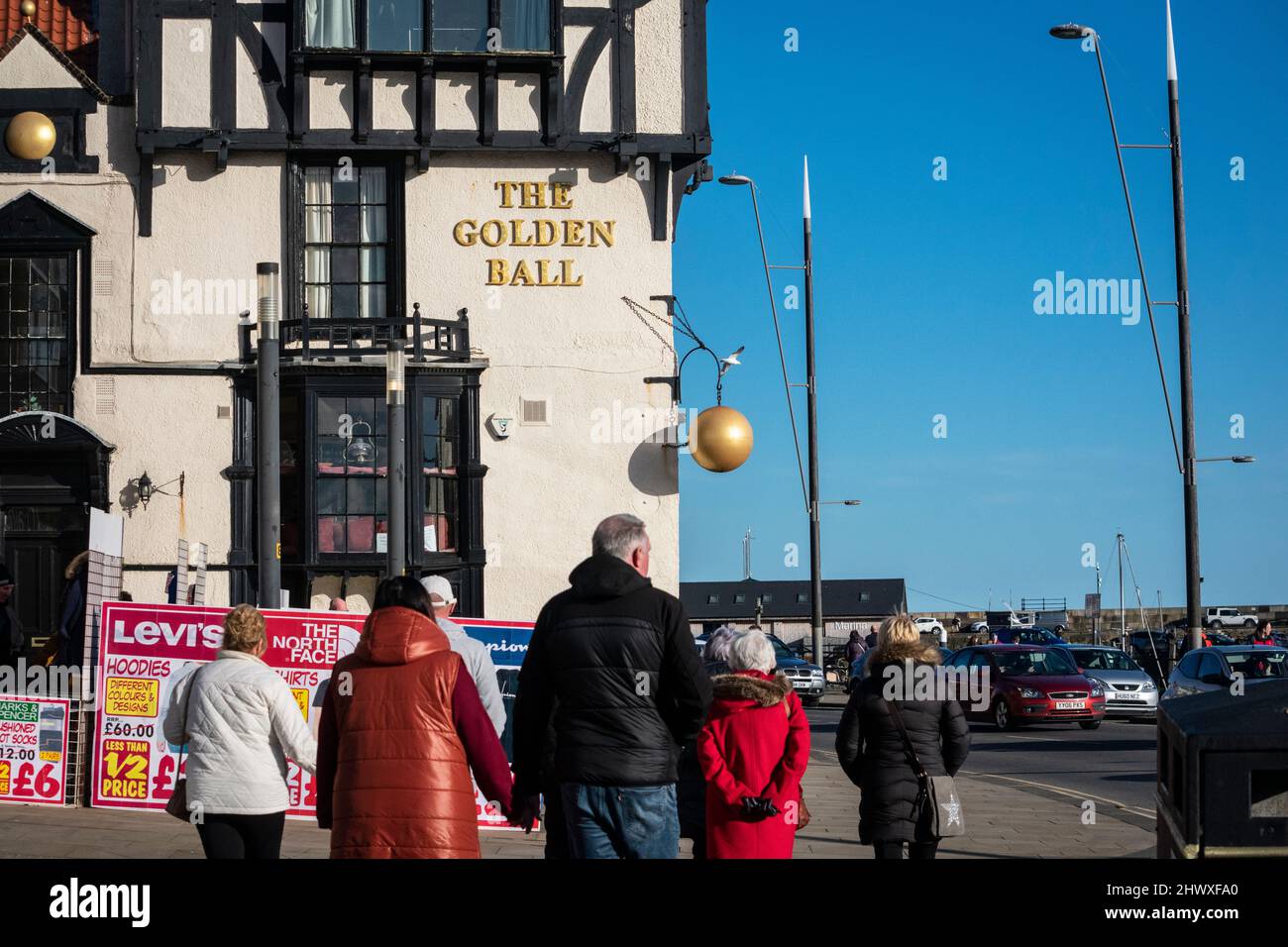 Crowds walking along the promenade by a pub in Scarborough, Yorkshire Stock Photo