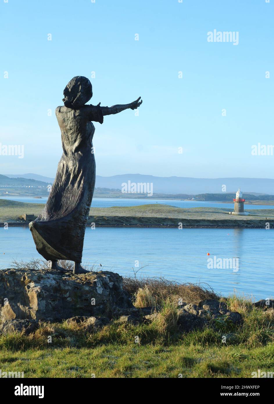 View from  from behind silhouette of statue across channel towards Oyster Island with mountains visible. Rosses Point, Slgo, Ireland Stock Photo