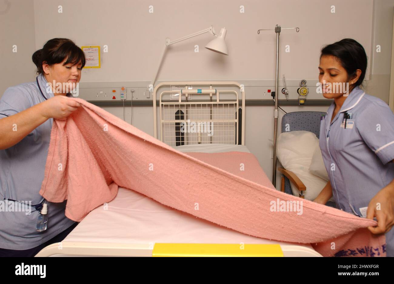 Two staff nurses make a bed in a hospital ward.(MODEL RELEASED Stock