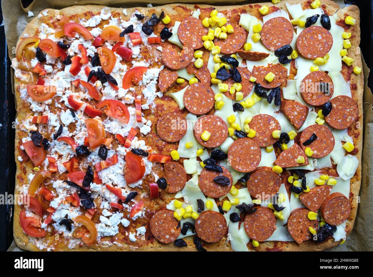 Top view of a raw pizza, one half is healthy diet pizza with tomato and