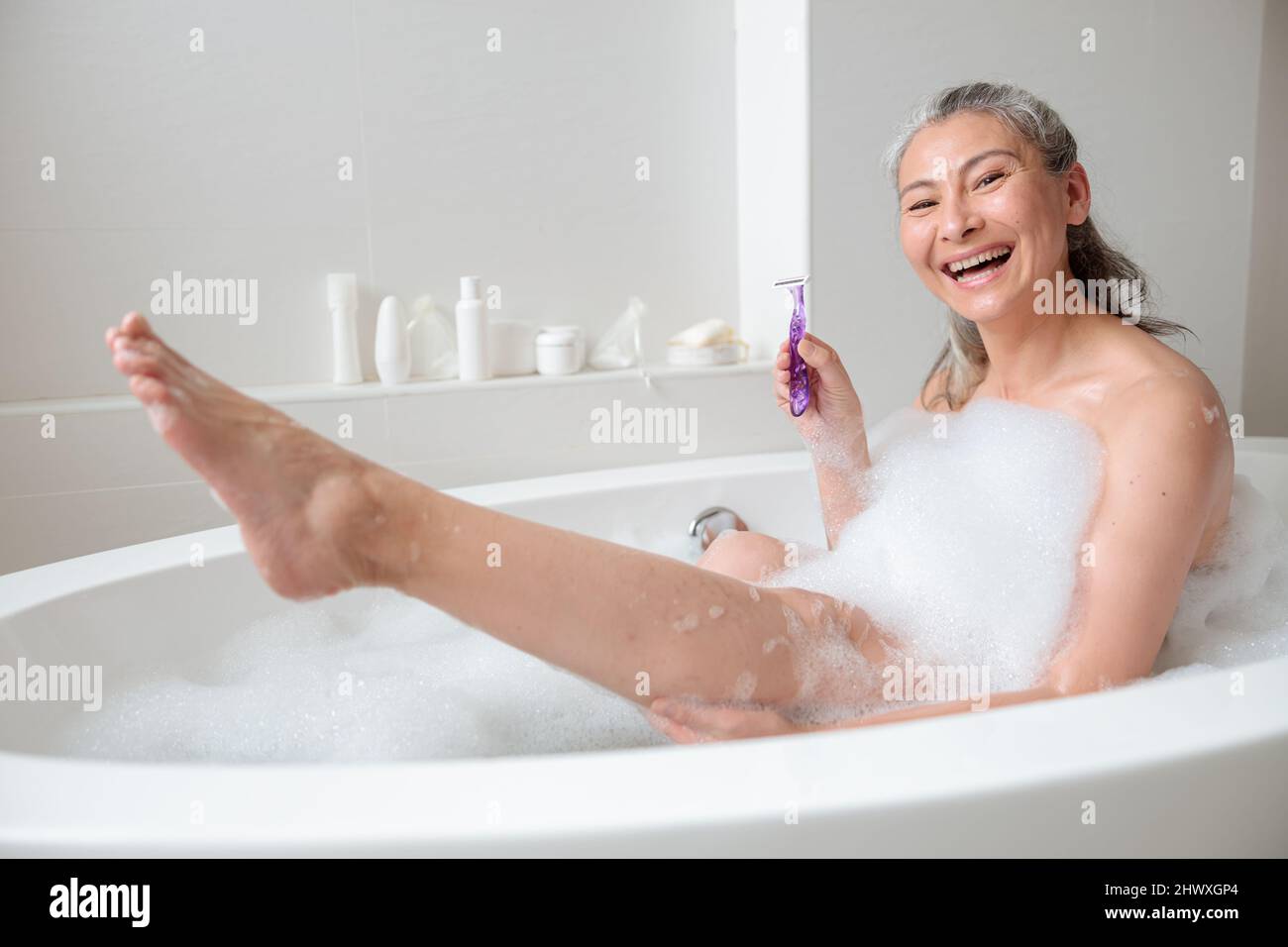 Smiling lady preparing to remove leg hair Stock Photo Alamy