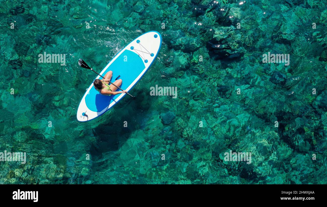 A young girl enjoying the tropical weather kneeling on a stand up