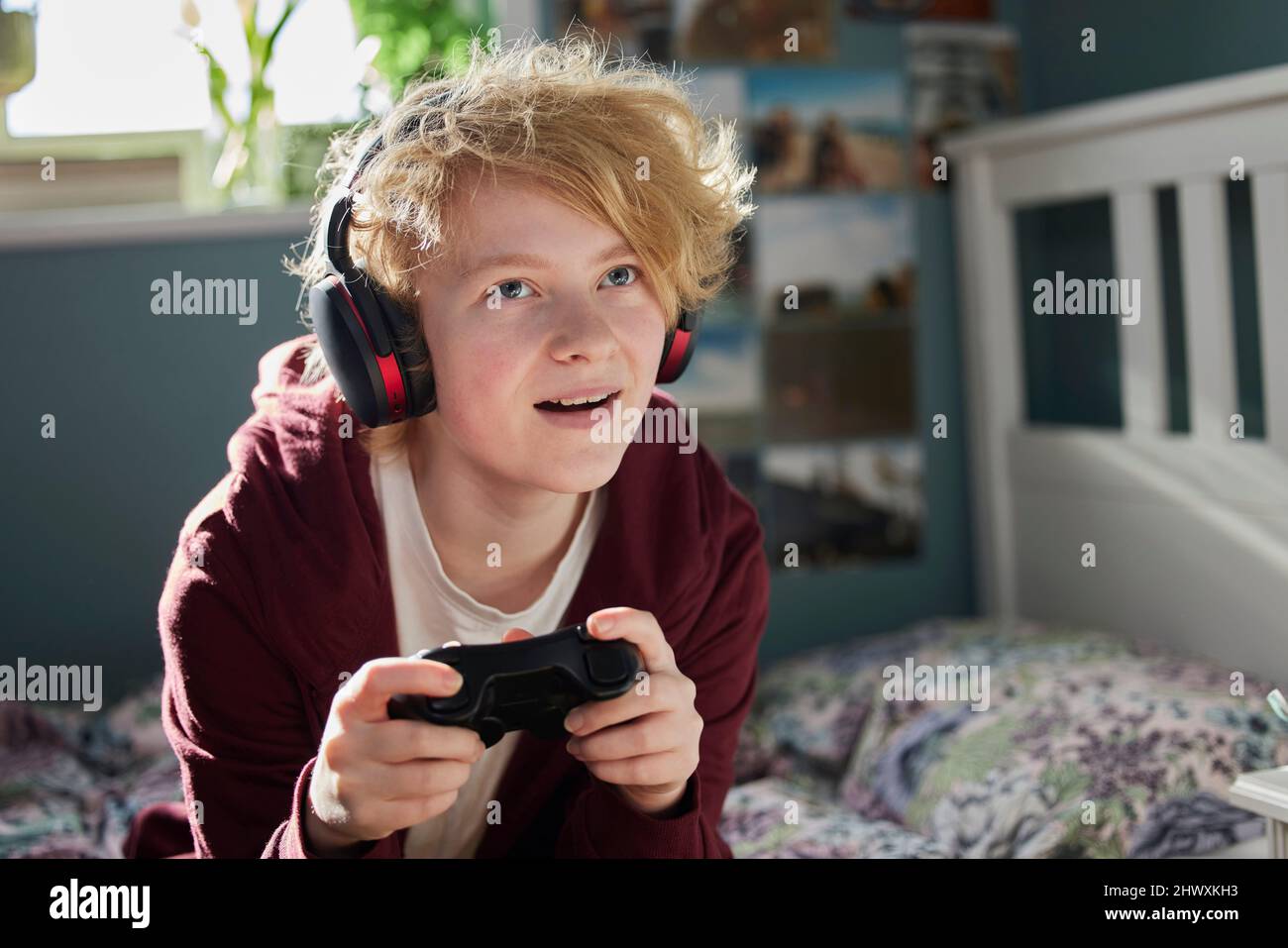 Excited Teeange Girl With Wireless Headphones Gaming Online In Bedroom At Home Stock Photo