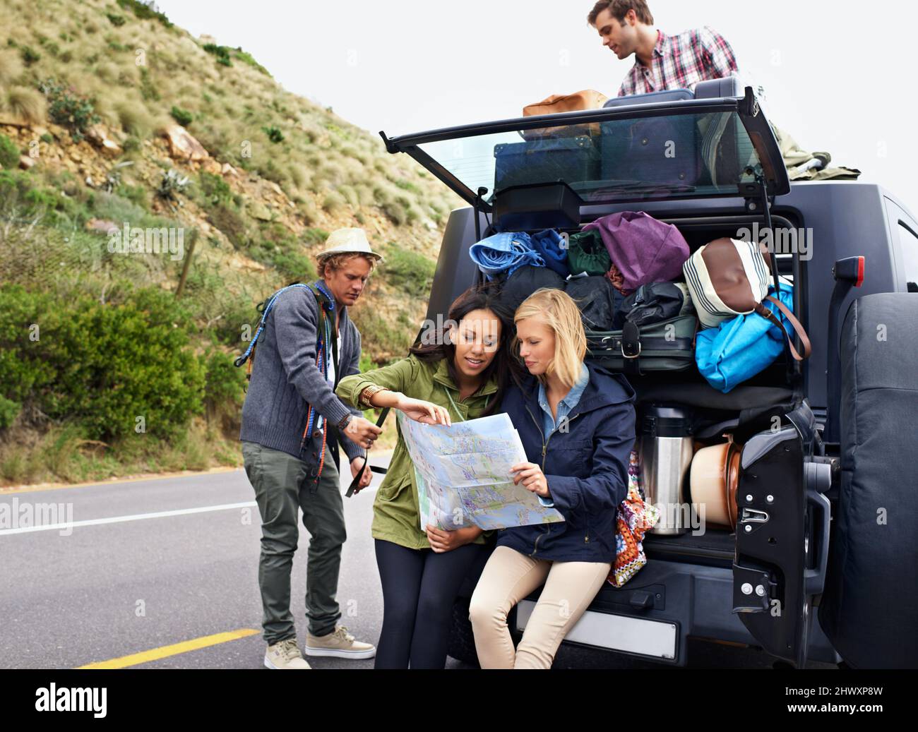 Planning the perfect road trip. A group of young friends preparing for their camping trip. Stock Photo