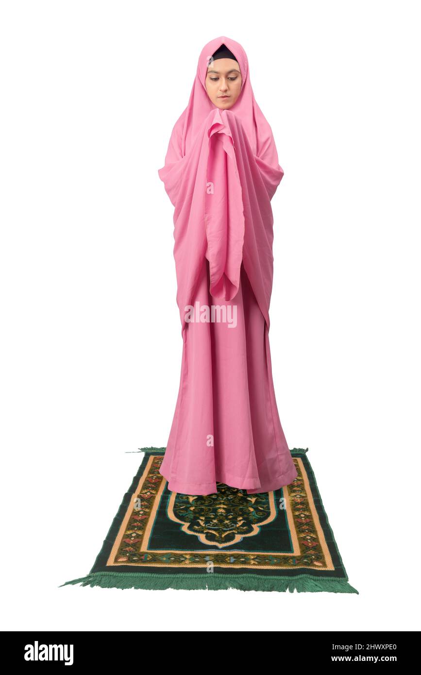 Asian Muslim woman in a veil standing while raised hands and praying ...